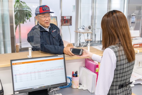 写真：事務所では着荷したドライバーに作業端末を手渡すなど現場に合わせた運用が可能