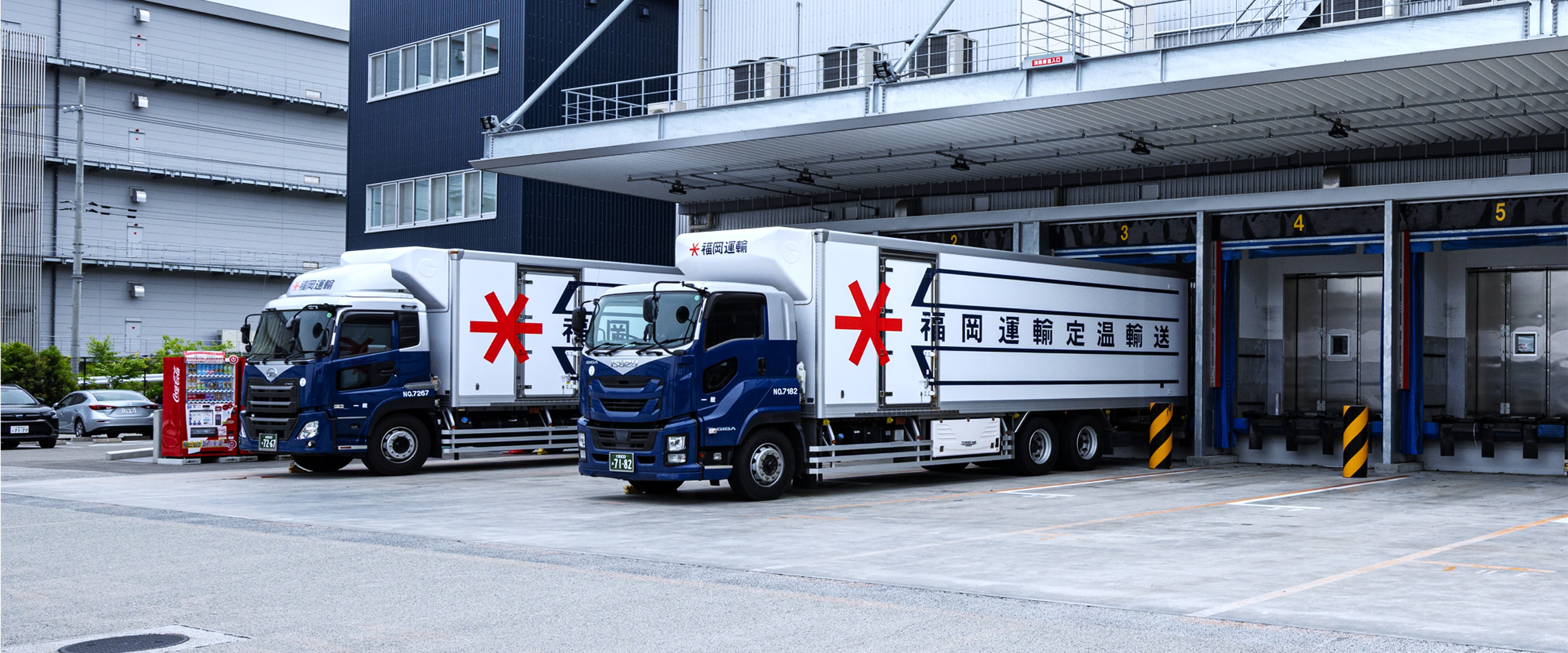 福岡運輸の大きな倉庫に駐車しようとしている大型トラック